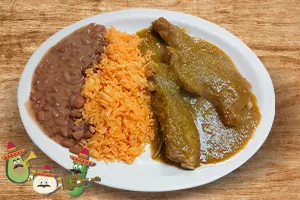 Pork ribs in green sauce served with rice, beans, and corn tortillas