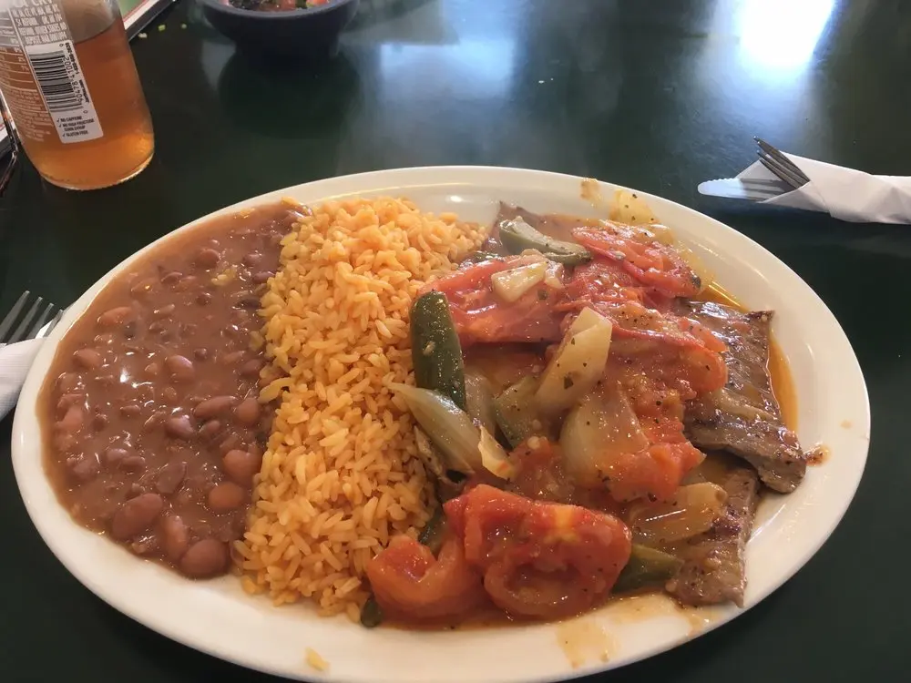 Grilled steak platter served with rice, beans, and corn tortillas